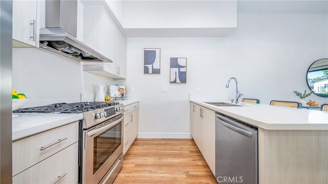 a kitchen with stainless steel appliances a stove and white cabinets