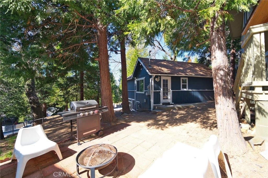 29083 Hook Creek Road Cedar Glen, CA 92321 - Photo 39 of 50 a view of a backyard with table and chairs and a fire pit