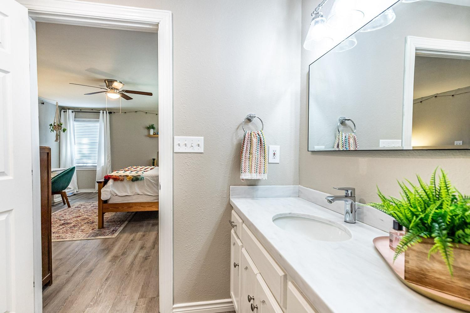 5221 14th Street Lubbock, TX 79416 - Photo 20 of 34 a en suite bathroom with a sink and a mirror