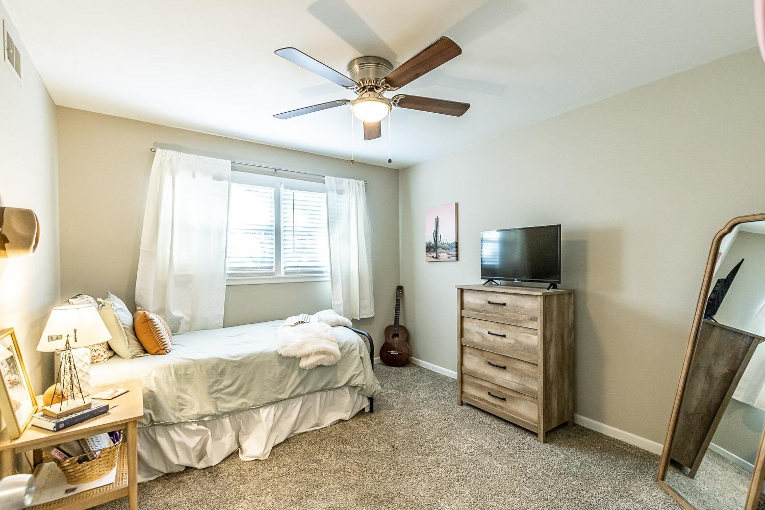 5221 14th Street Lubbock, TX 79416 - Photo 21 of 34 a bedroom with a bed and flat screen tv