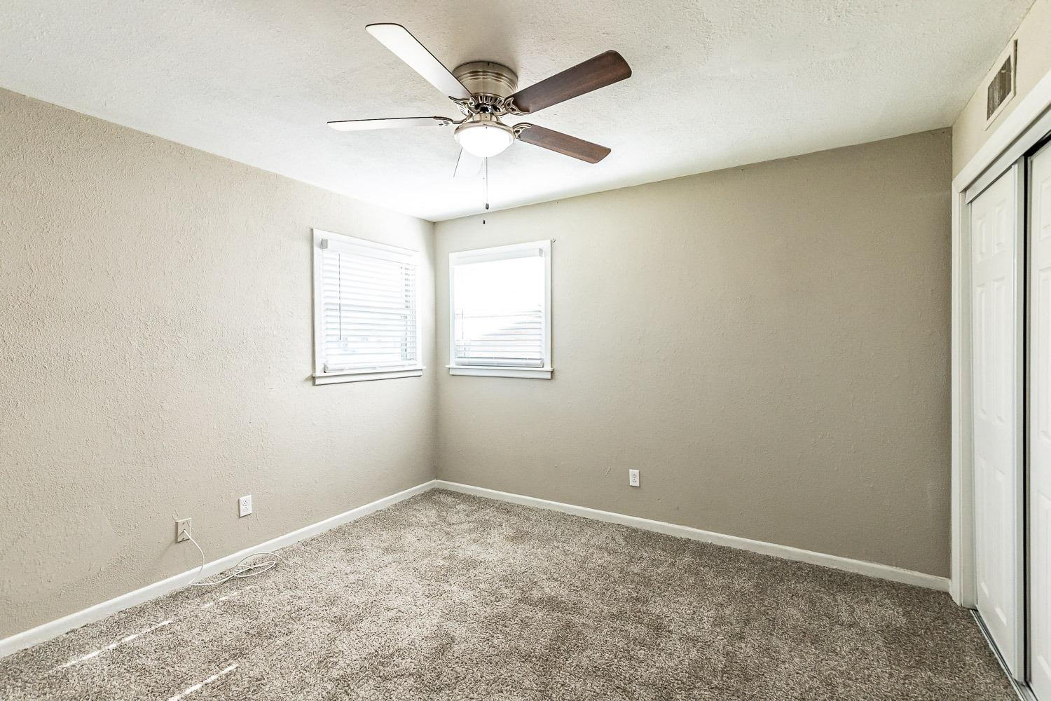 5221 14th Street Lubbock, TX 79416 - Photo 26 of 34 an empty room with a window and a fan
