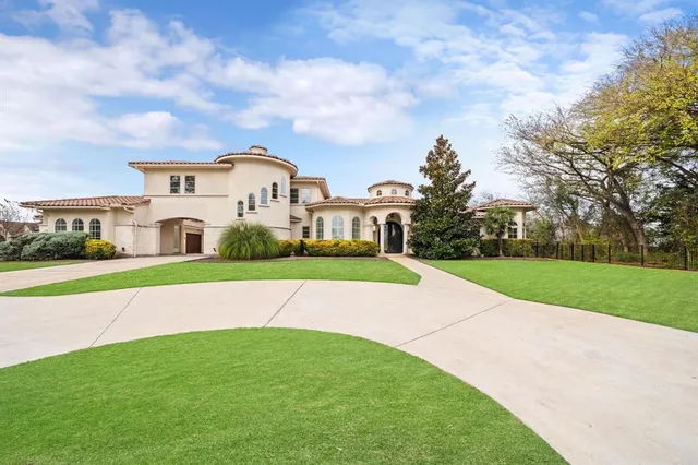 a view of a white house with a big yard and large trees