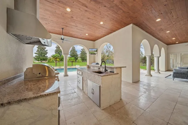 a view of a swimming pool with a yard and a fountain in the background