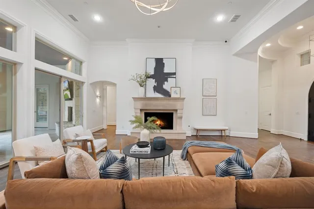 a living room with couches a fireplace and kitchen view