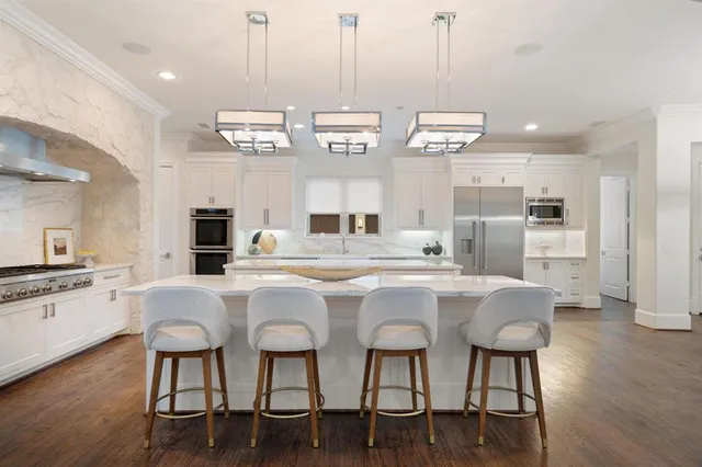 a large white kitchen with a table and chairs