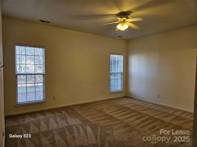 a view of room with a ceiling fan and window