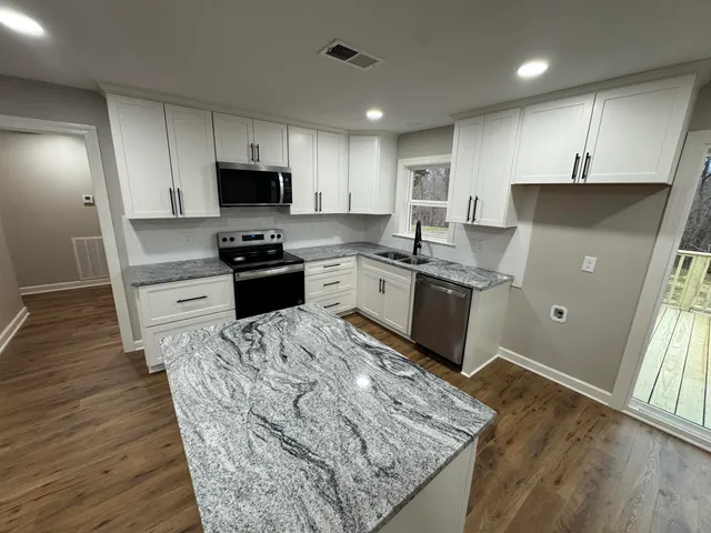 a kitchen with cabinets and wooden floor