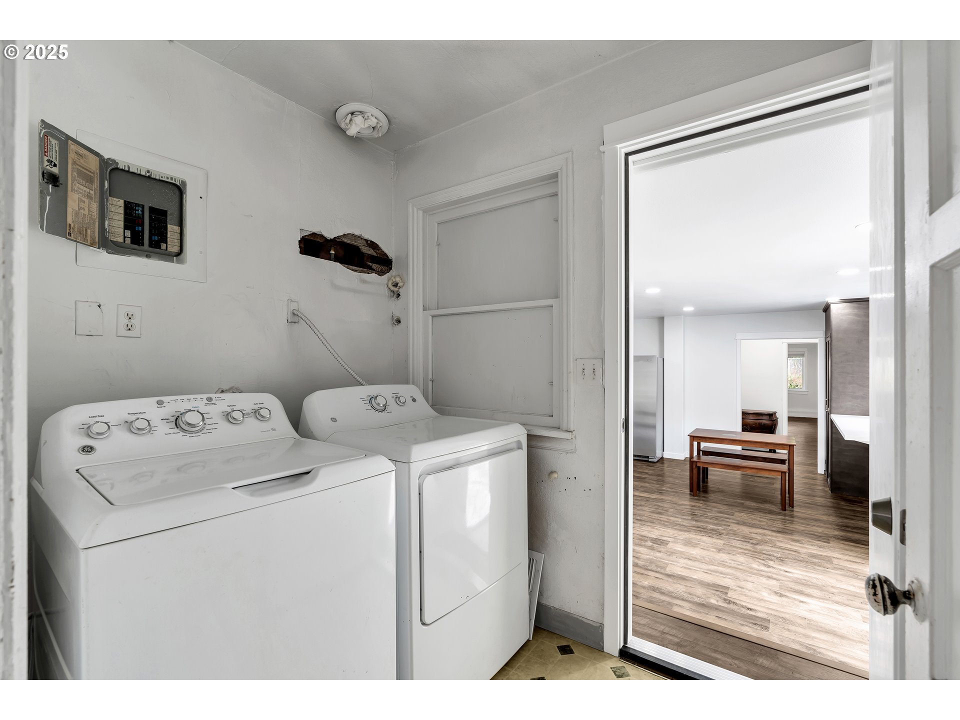 8451 Southeast Bush Street Portland, OR 97266 - Photo 15 of 47 a view of washer and dryer with kitchen in the background