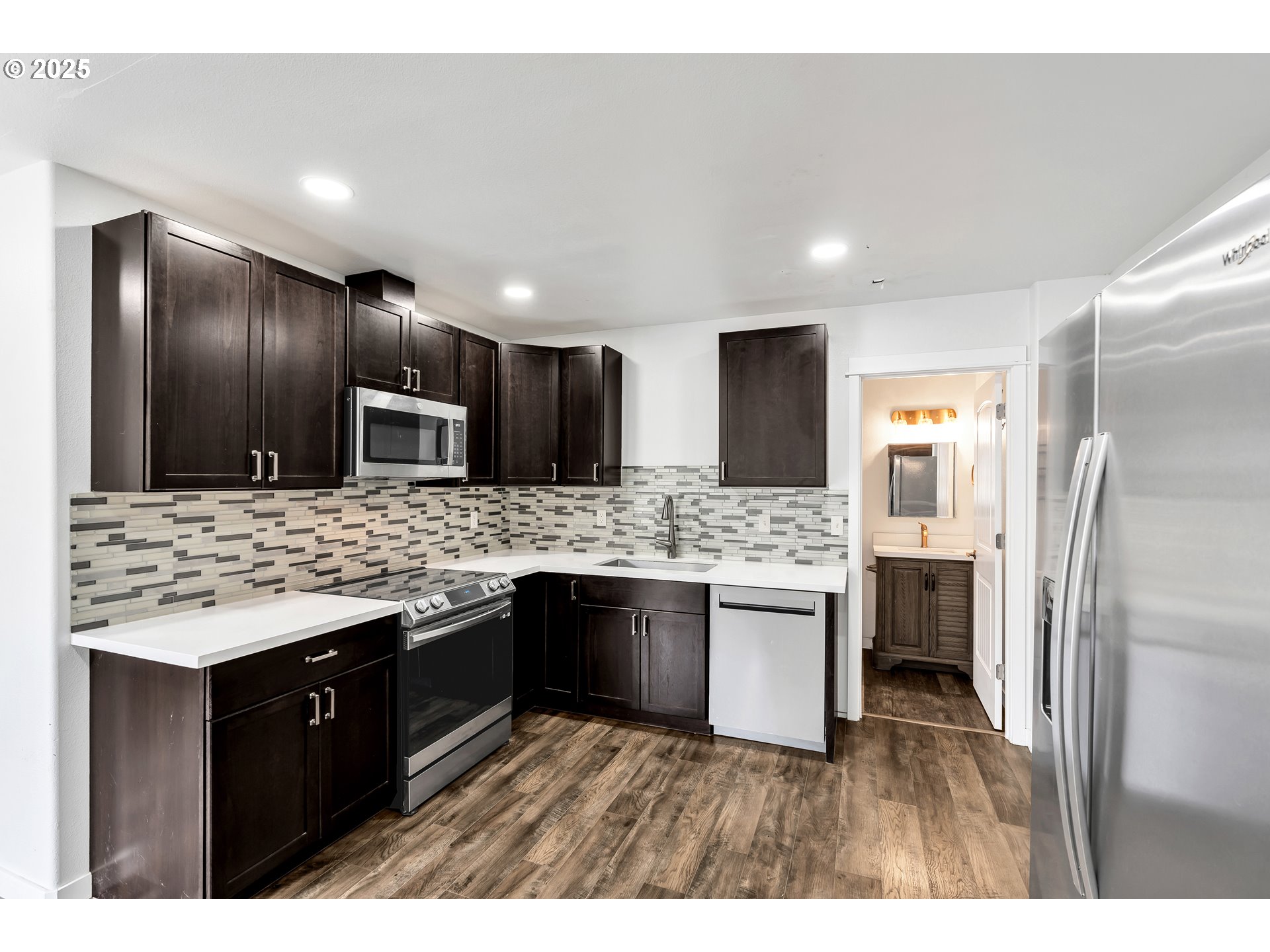 8451 Southeast Bush Street Portland, OR 97266 - Photo 16 of 47 a kitchen with a sink and refrigerator