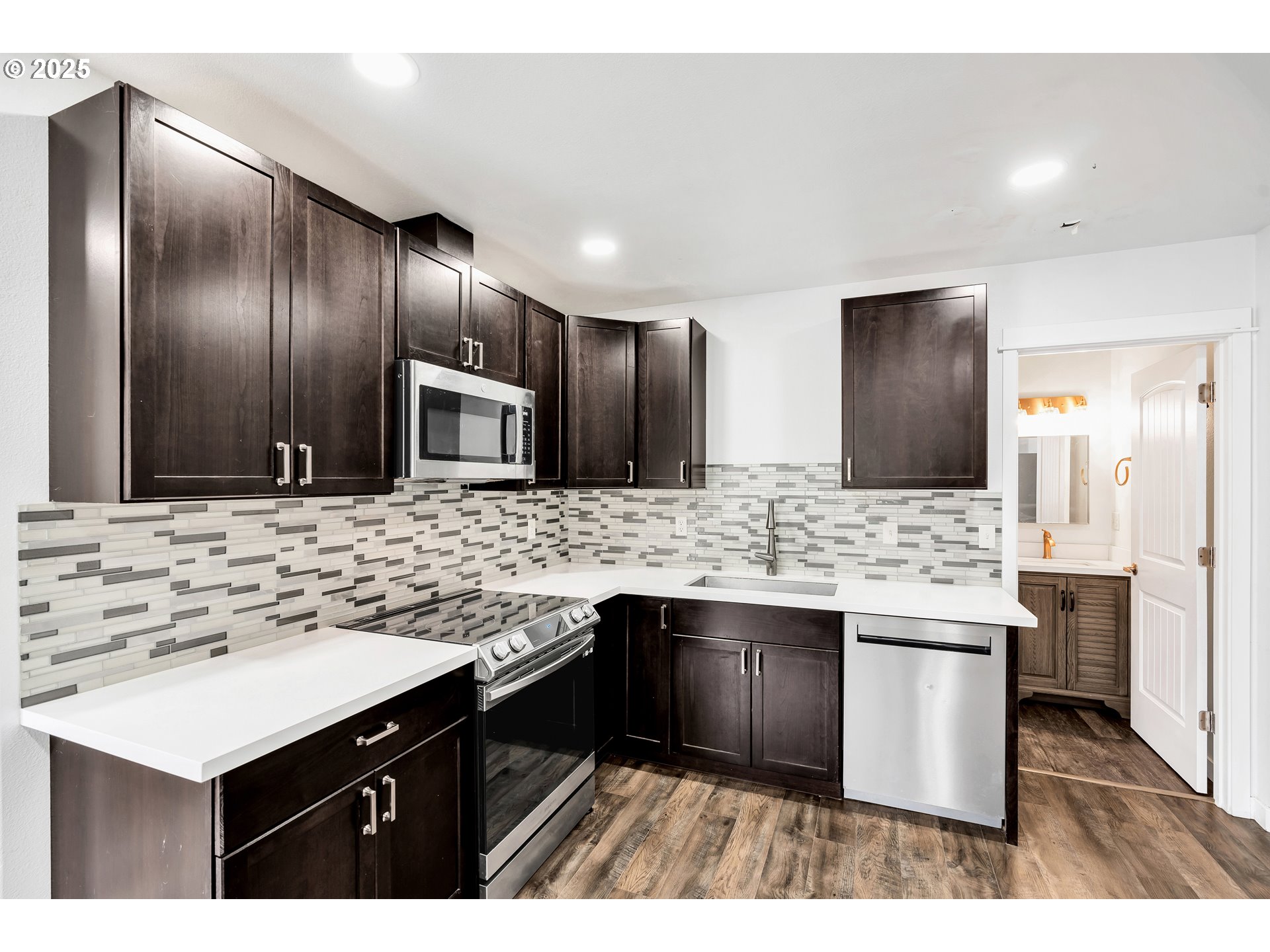 8451 Southeast Bush Street Portland, OR 97266 - Photo 18 of 47 a kitchen with stainless steel appliances kitchen island granite countertop a sink stove and refrigerator