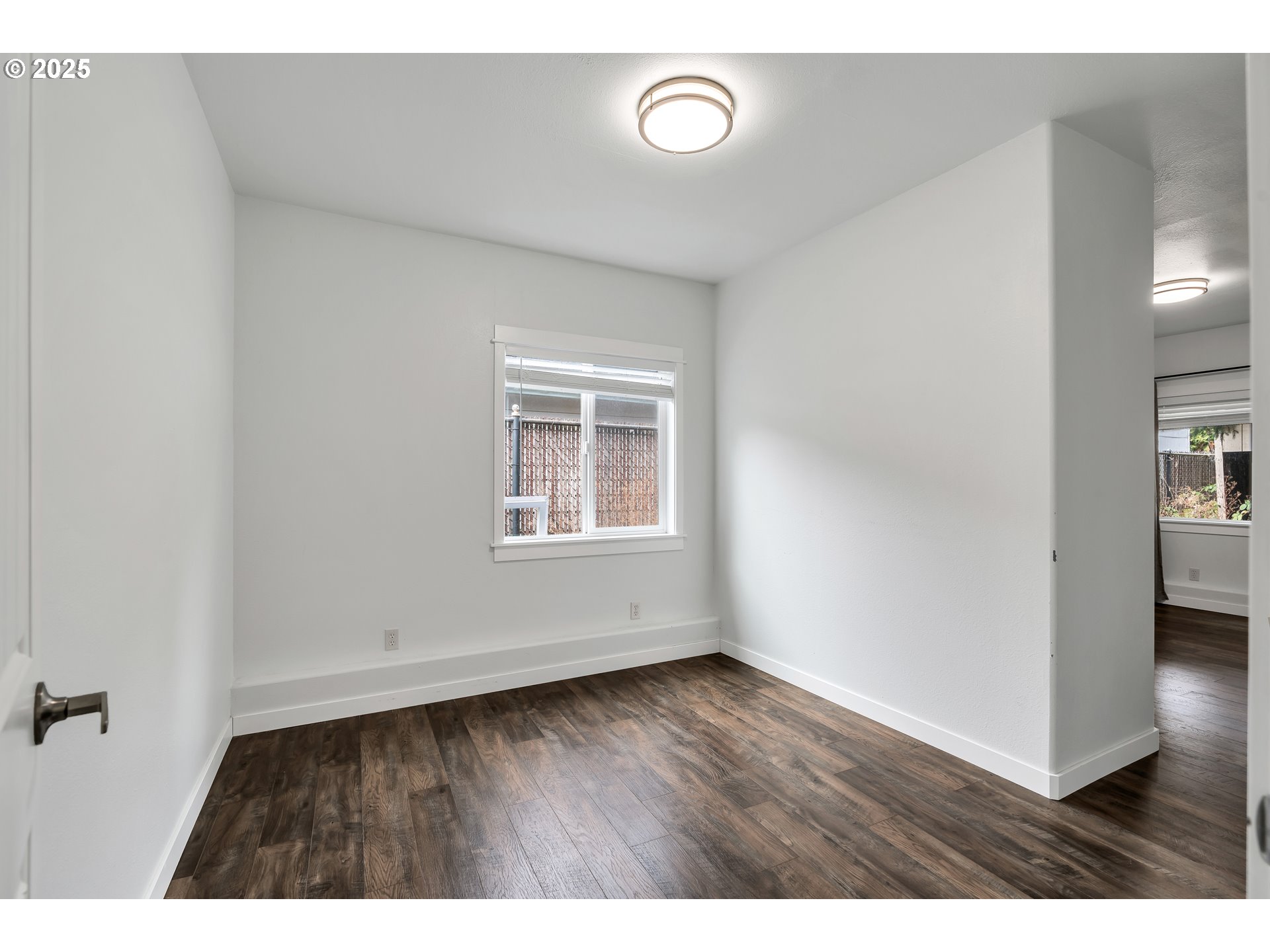 8451 Southeast Bush Street Portland, OR 97266 - Photo 25 of 47 a view of an empty room with wooden floor and a window