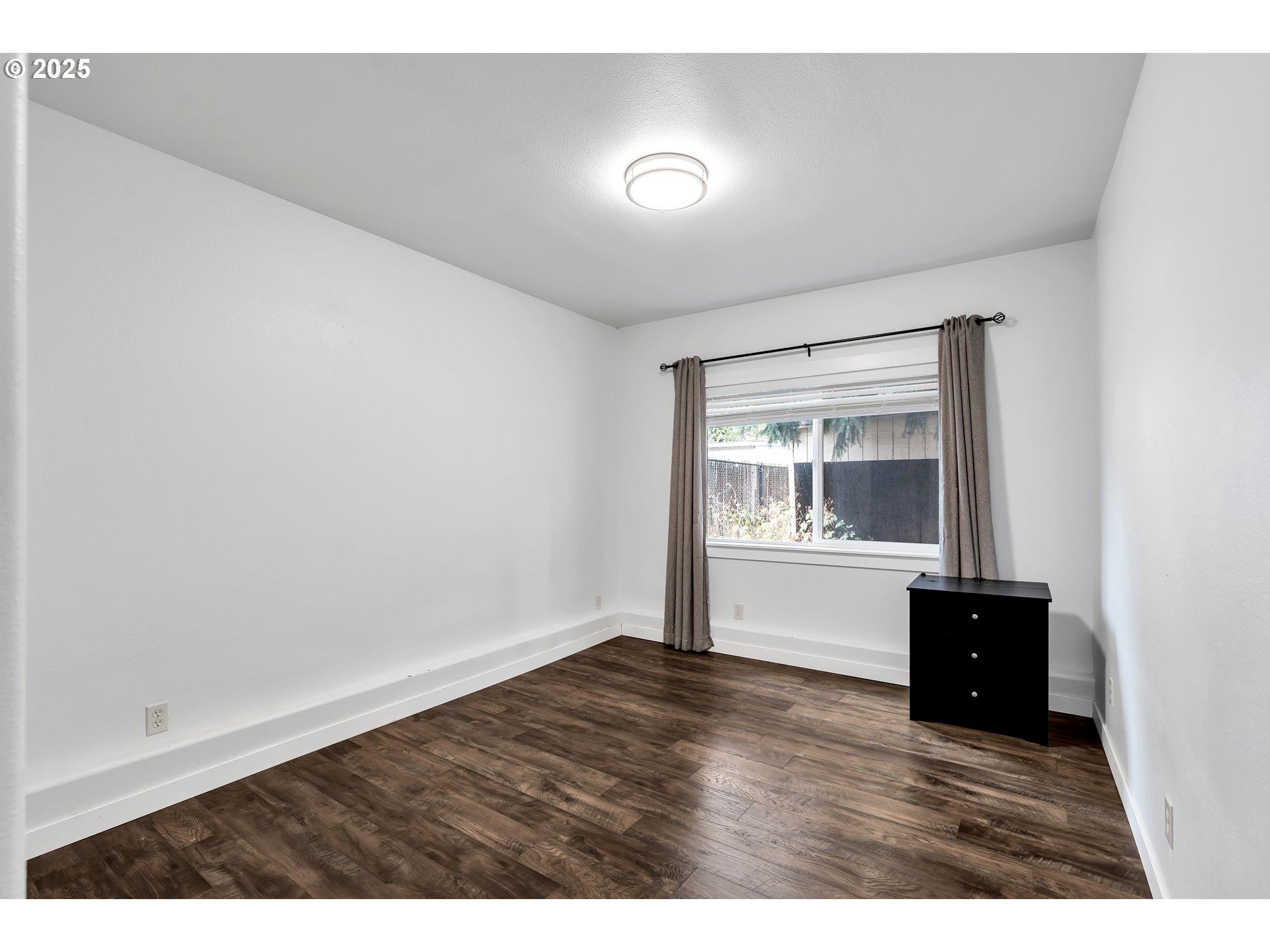 8451 Southeast Bush Street Portland, OR 97266 - Photo 27 of 47 a view of an empty room with wooden floor and a window