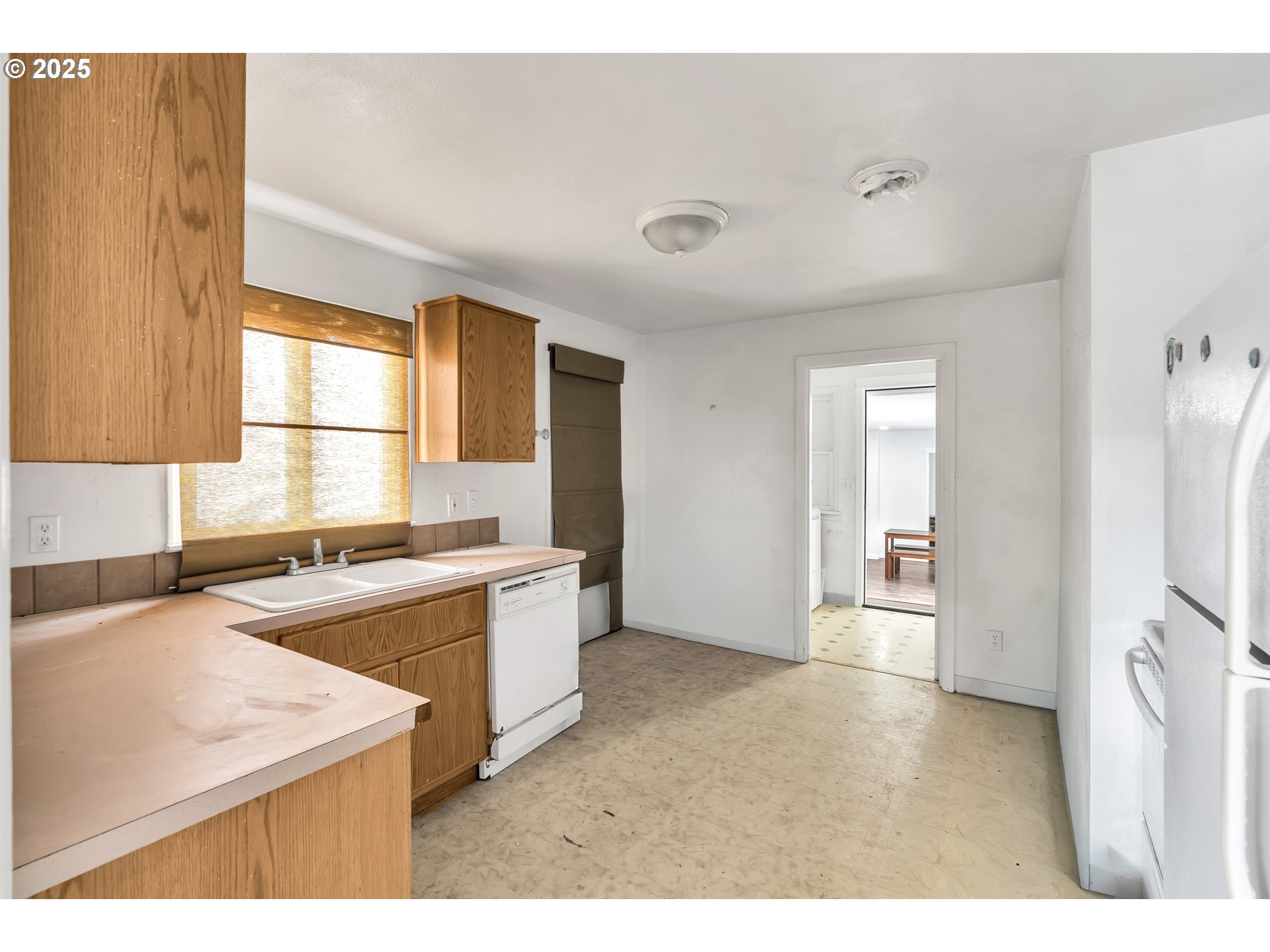 8451 Southeast Bush Street Portland, OR 97266 - Photo 8 of 47 a kitchen with a stove a sink and a refrigerator
