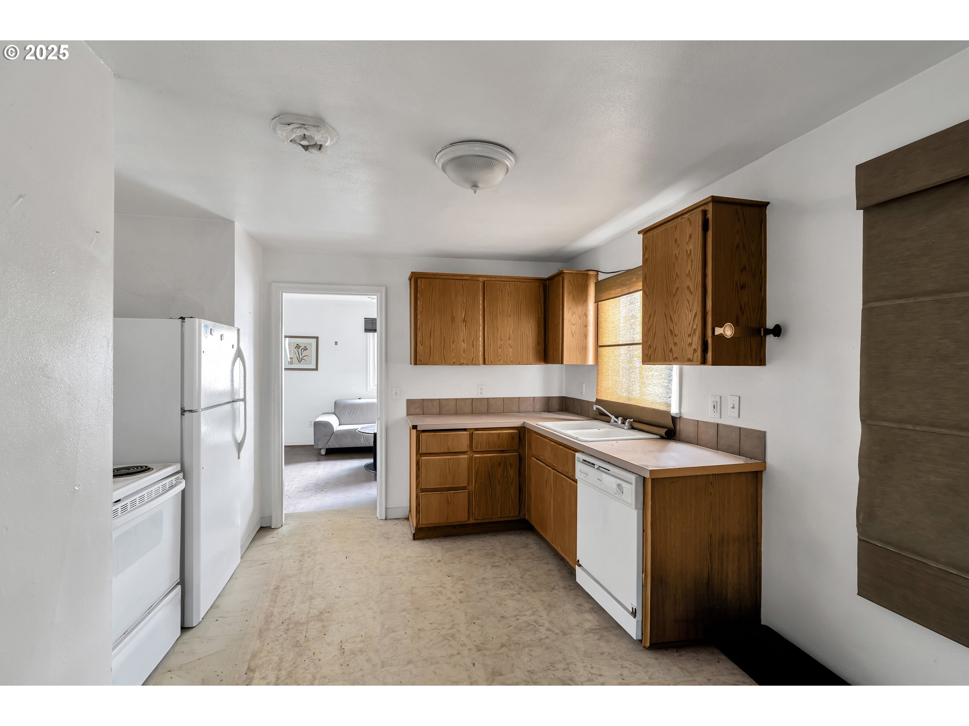 8451 Southeast Bush Street Portland, OR 97266 - Photo 9 of 47 a kitchen with a sink stove and refrigerator