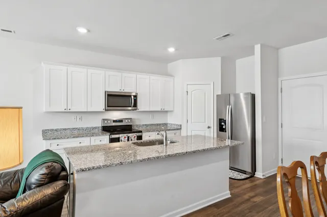 a kitchen with stainless steel appliances granite countertop a refrigerator and a stove top oven
