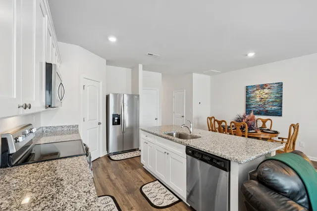 a view of a kitchen with a sink dishwasher stove and refrigerator