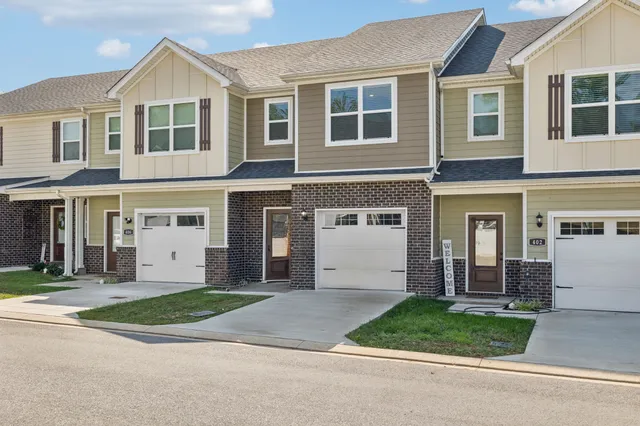 a front view of a house with a garden and garage