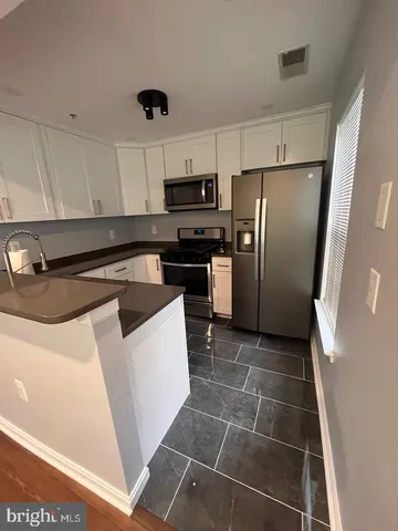 a kitchen with granite countertop a refrigerator and a sink