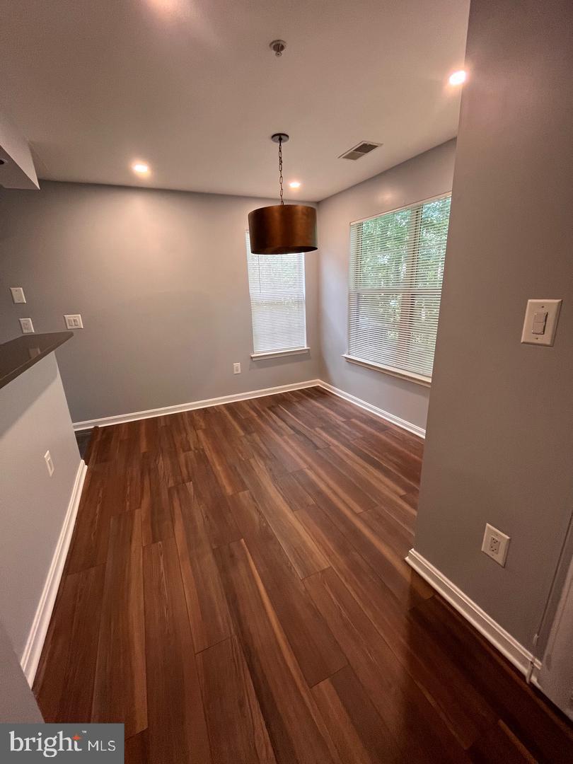 109 Timberbrook Lane, Unit T2 Gaithersburg, MD 20878 - Photo 5 of 10 an empty room with wooden floor and windows