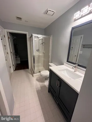 a bathroom with a sink a toilet a mirror and shower