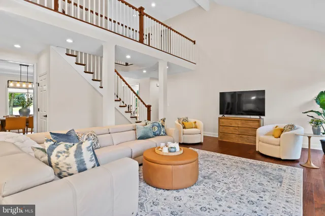 a dining room filled chandelier and wooden furniture