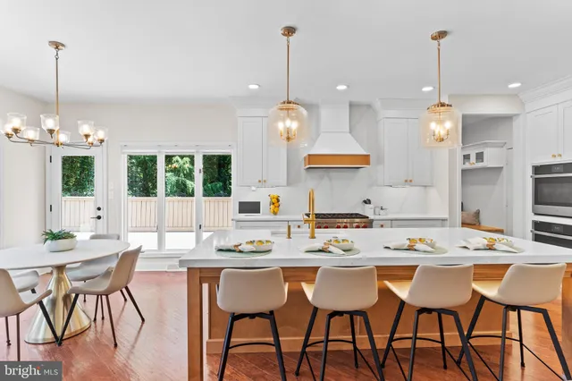 a large kitchen with kitchen island a large counter space a sink stainless steel appliances and cabinets