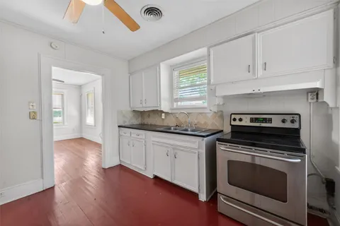 a kitchen with granite countertop a stove and a sink
