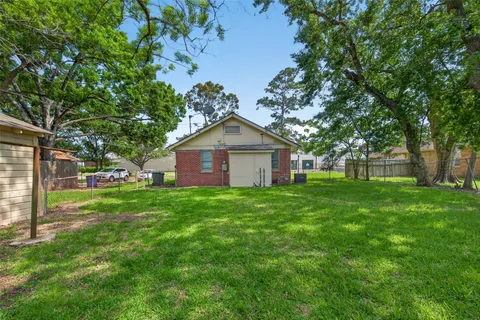 a view of a yard in front of a house with large trees