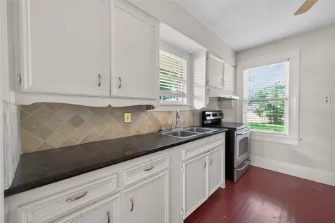 a kitchen with granite countertop white cabinets and white appliances