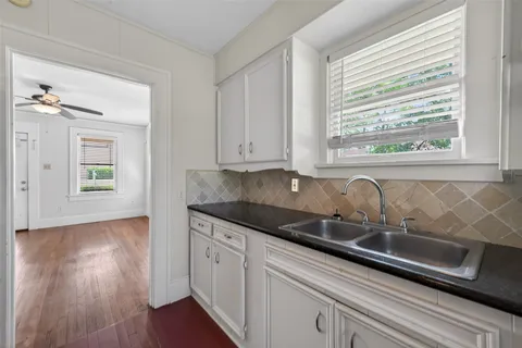 a kitchen with granite countertop stainless steel appliances a sink window and cabinets