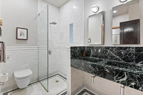 a bathroom with a toilet a sink and mirror