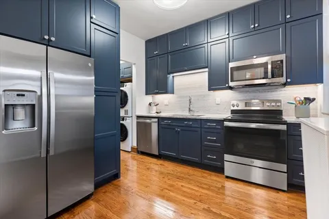 a kitchen with stainless steel appliances granite countertop cabinets and a wooden floor