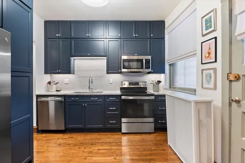 a view of kitchen with stainless steel appliances granite countertop a refrigerator and a sink