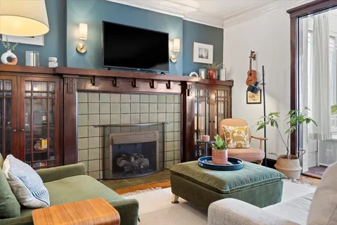 a living room with furniture a flat screen tv and a fireplace