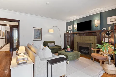 a living room with furniture a flat screen tv and a fireplace