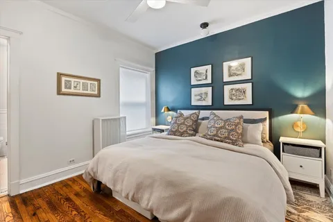 a bedroom with a bed and painting on the wall