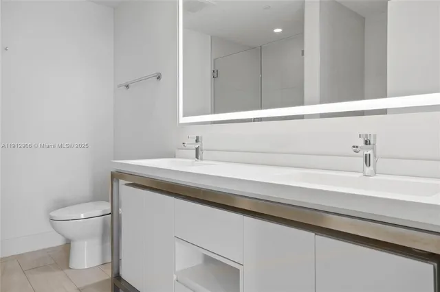 a bathroom with a sink a toilet and mirror