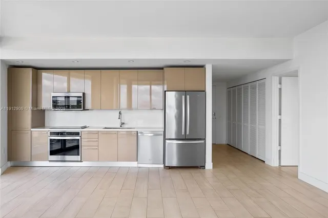 a kitchen with stainless steel appliances granite countertop a refrigerator and a stove top oven