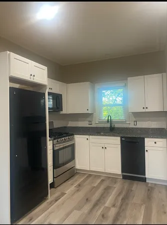 a kitchen with granite countertop a sink stove and refrigerator