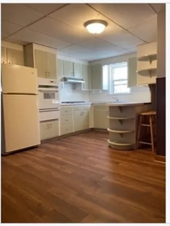 a kitchen with a refrigerator and white cabinets