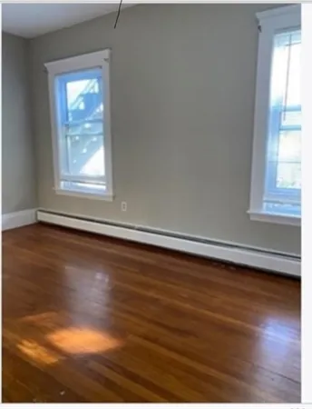 a view of a livingroom with wooden floor and a window
