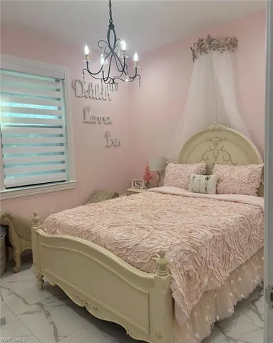 a bedroom with a bed and a chandelier