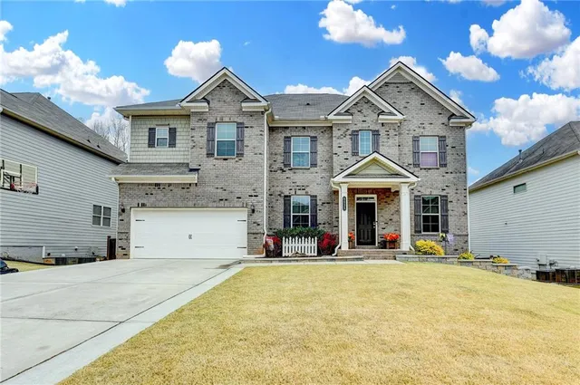a view of a white house with large windows and a small yard