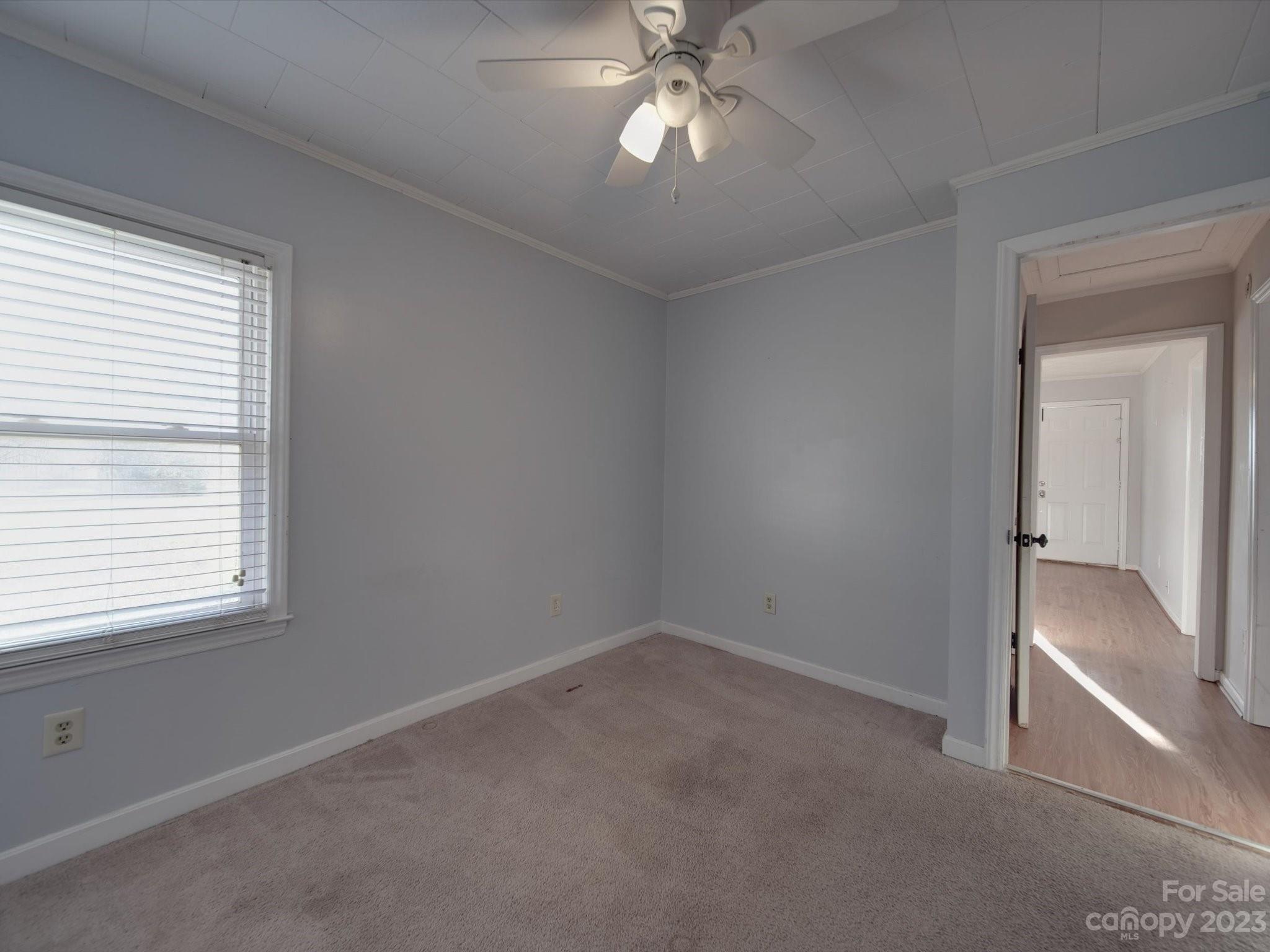 3319 Stack Road Monroe, NC 28112 - Photo 20 of 45 an empty room with a chandelier fan and windows
