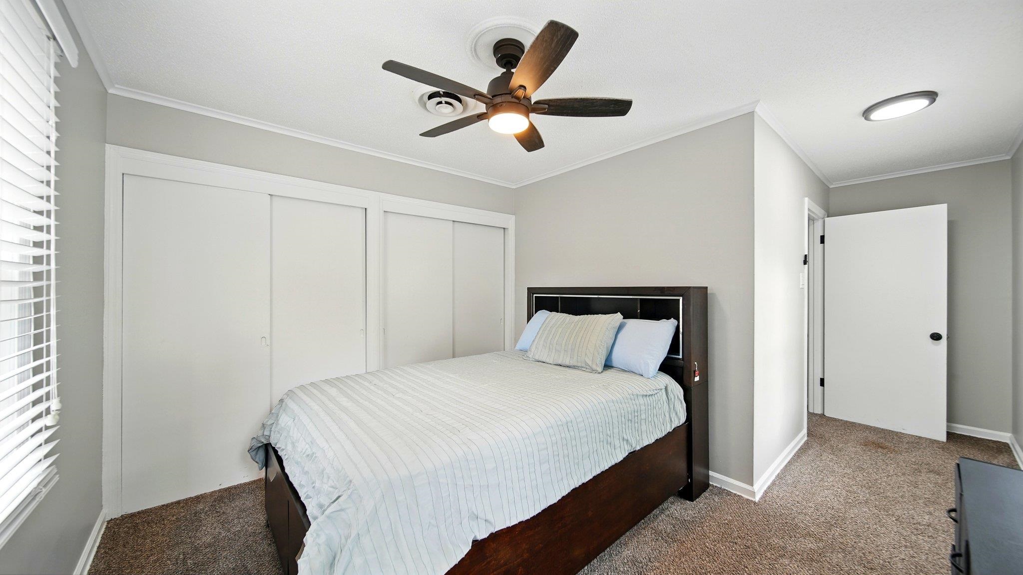 359 South Fenwick Road Memphis, TN 38111 - Photo 18 of 31 Carpeted bedroom featuring two closets, crown molding, and a ceiling fan