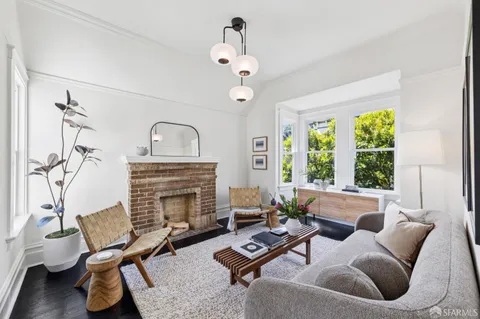 a living room with furniture a fireplace and floor to ceiling window