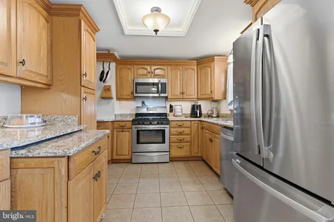 a kitchen with stainless steel appliances granite countertop a refrigerator sink and stove