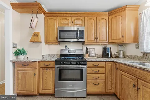 a kitchen with stainless steel appliances granite countertop a stove a sink and a microwave