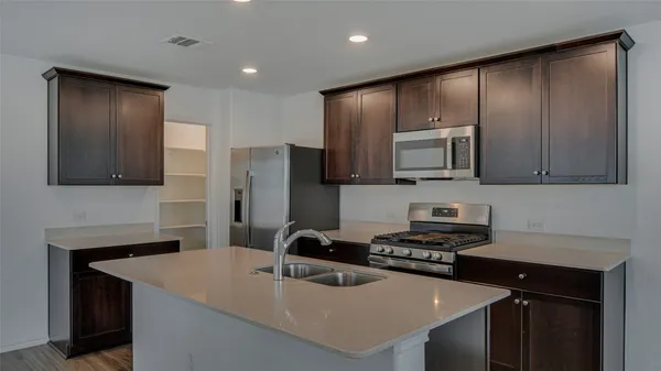a kitchen with a sink a stove a refrigerator and cabinets