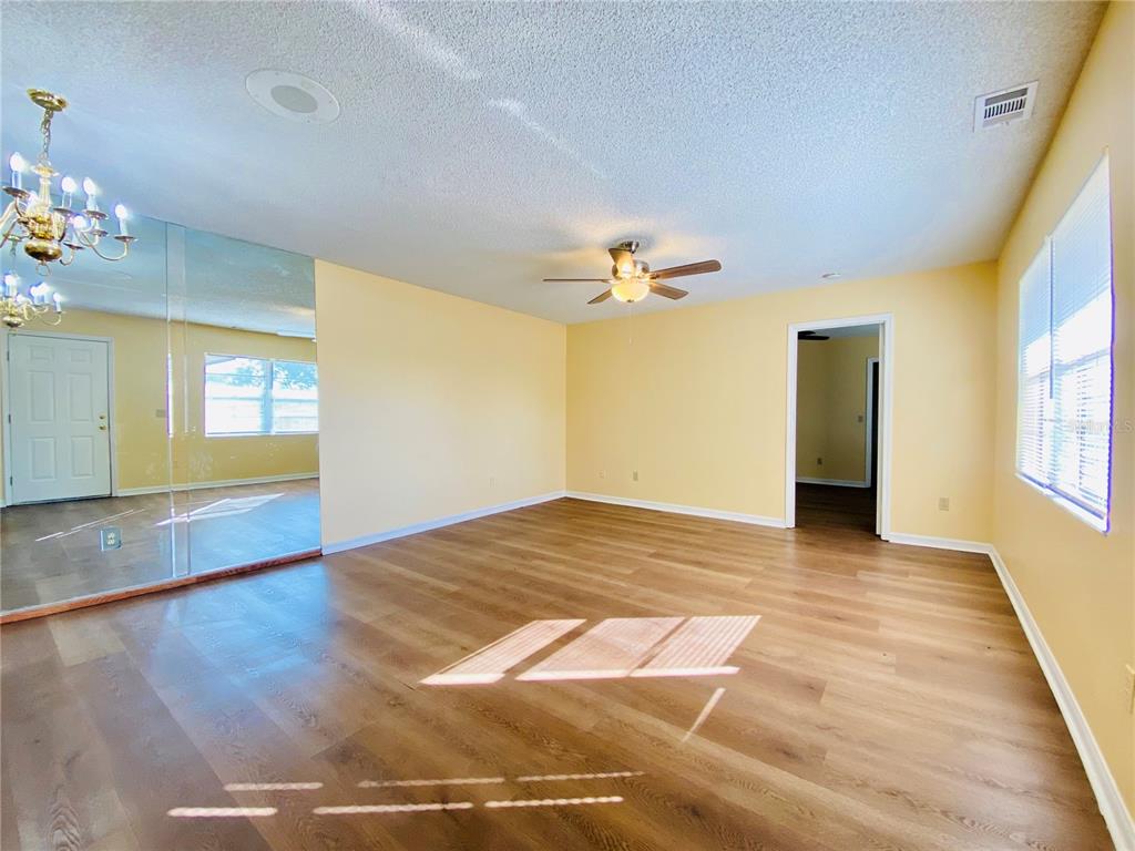64 Windtree Lane, Unit 203 Winter Garden, FL 34787 - Photo 4 of 13 a view of an empty room with window and wooden floor